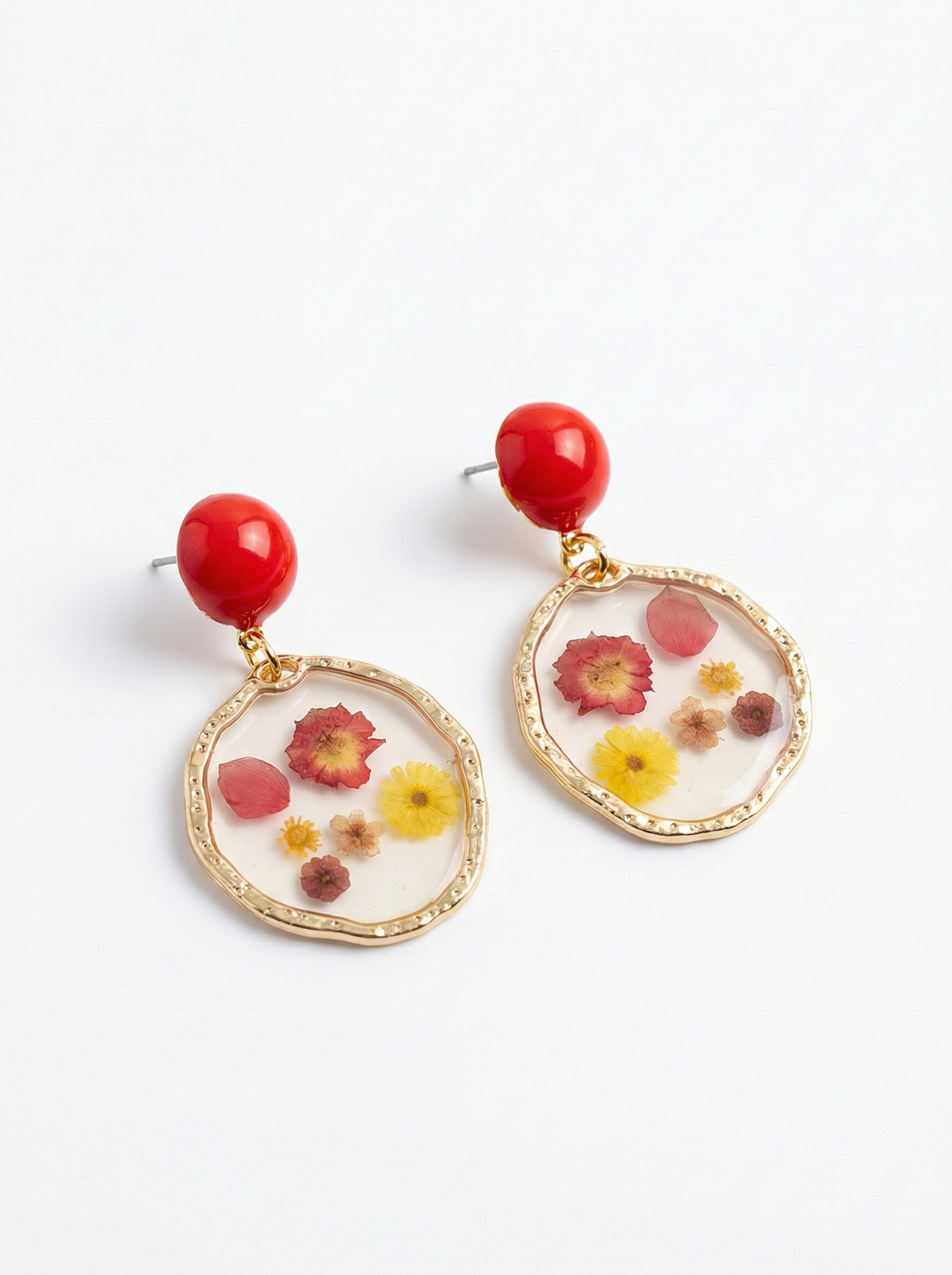 Earrings with red beads and floral designs on a white background