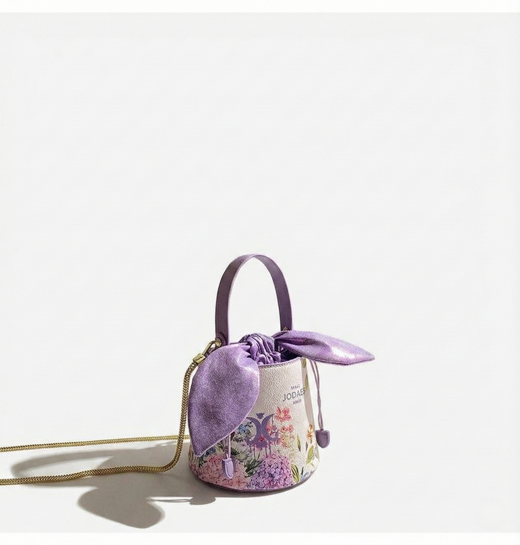 Small purple handbag with floral design on a white background