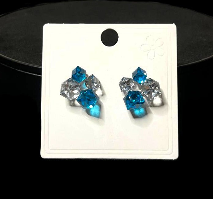 Pair of blue crystal earrings on a white card with a black background